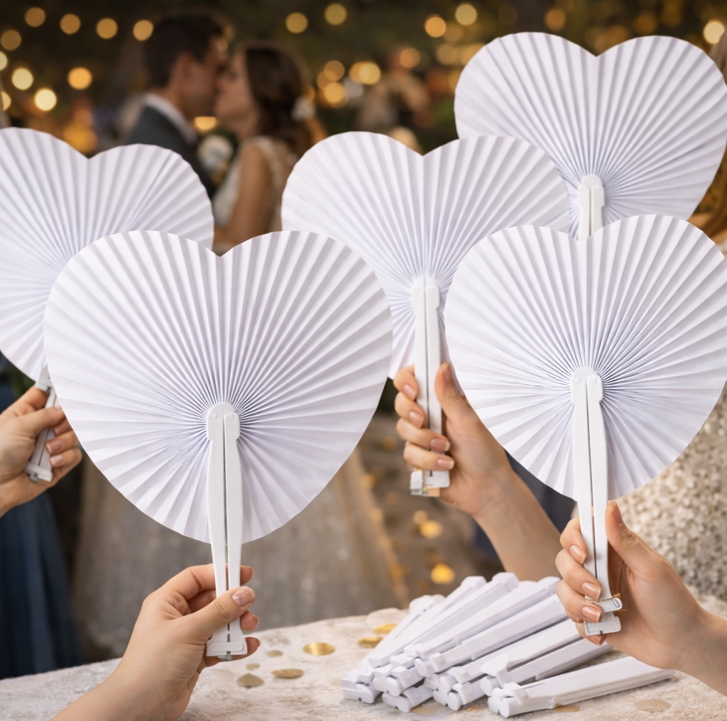 Weiße Papierfächer in Herzform für Hochzeitsgäste als romantische und praktische Ausstattung.