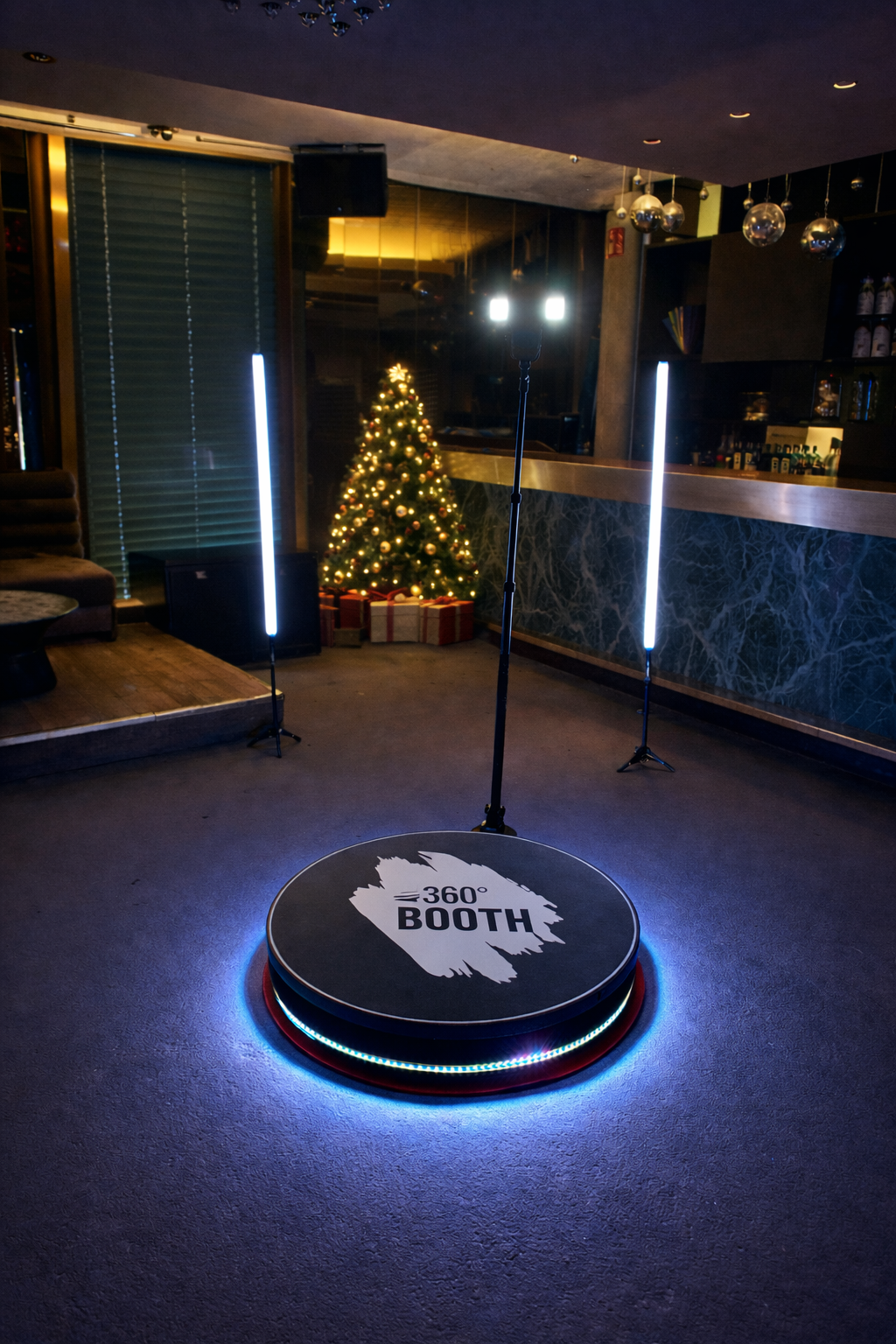 360° Video Booth auf einer Weihnachtsfeier mit festlicher Beleuchtung und Weihnachtsbaum im Hintergrund