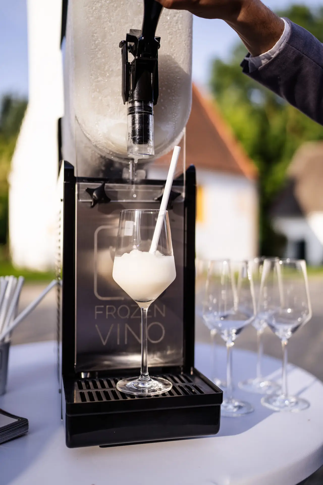 Detailaufnahme einer Frozen Vino Maschine mit frisch gezapftem Slush Wein im Glas